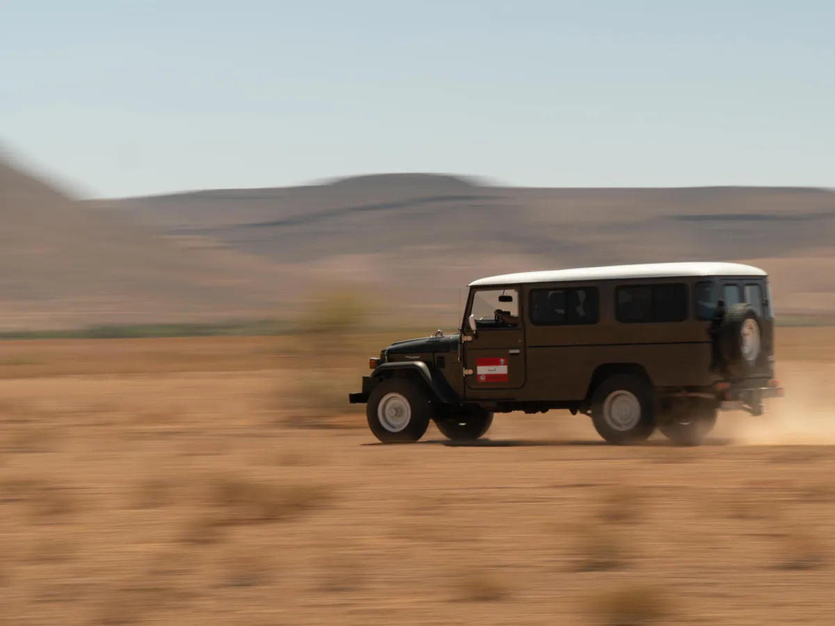 Geländewagen in Fahrt durch eine Wüstenlandschaft